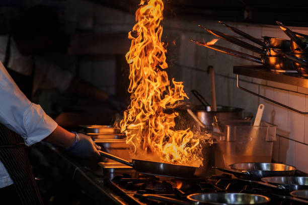 istock Closeup image of chief cook holding roasted meat at open fire grill kitchen background. 1461615247
