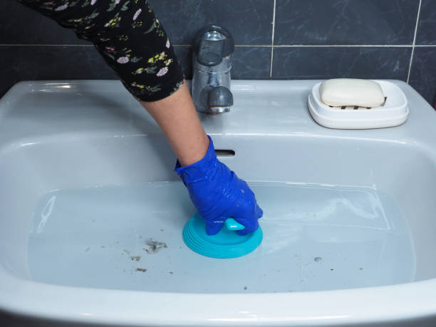 istock Sink with dirty water and plunger in hand clears blockage 1461617042