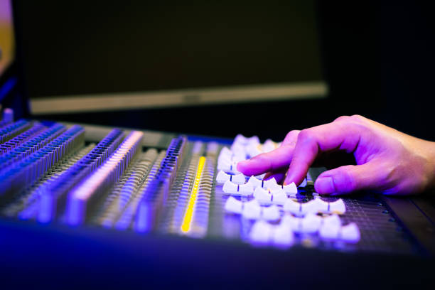 sound engineer fingers on audio mixing console fader in recording, broadcasting studio stock photo