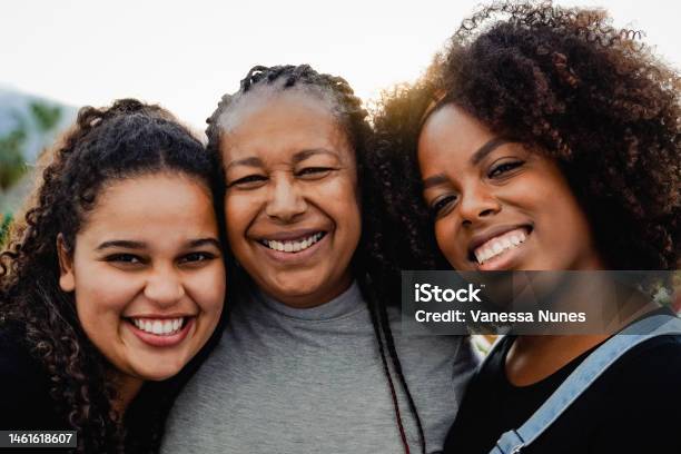 Portrait Of Happy African Mother And Daughters Having Fun Outdoor Looking At Camera Love Family Concept Focus On Right Girl Stock Photo - Download Image Now