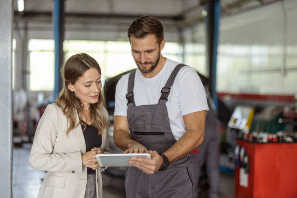Car Mechanic and Customer Using Digital Tablet Auto repairman and businesswoman using digital tablet at car service workshop auto repair shop mechanic digital tablet customer stock pictures, royalty-free photos & images