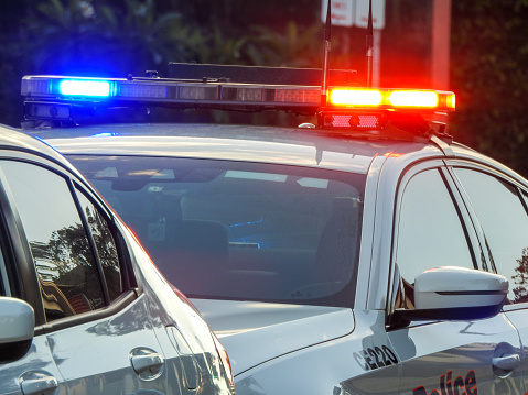 An officer of the NSW Police Highway Patrol, driving a BMW Series 7 vehicle, has pulled over the driver of a vehicle on Bondi Road, Bondi.  The officer has activated the vehicle flashing lights.  This image was taken at dusk on 2 February 2023.