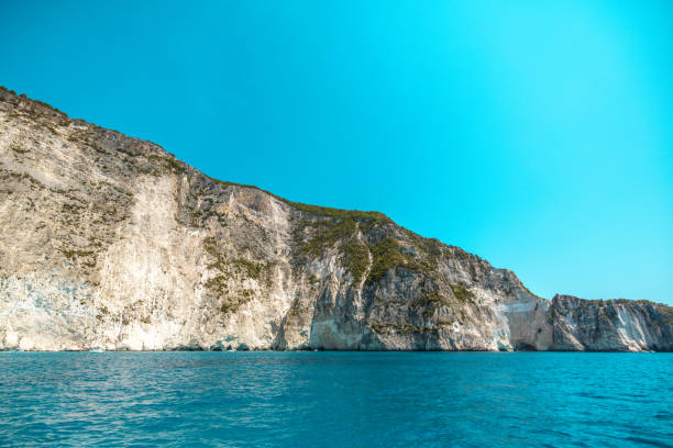 Beautiful view of the cliffs in Greece from the boat. The cliffs are steep and high. The water is blue and calm. The weather is amazing. Beautiful relaxing vacation spot.