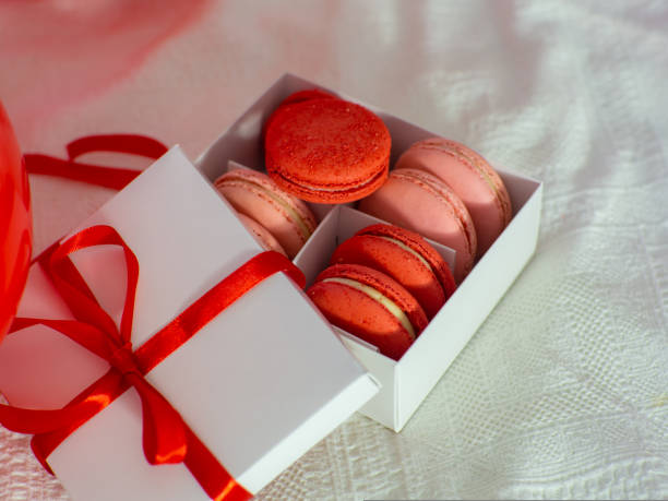 istock Box with macaron cookies and red baloons on the bed 1461623675