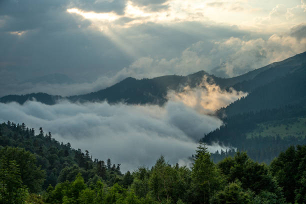 Aerial view of mountain range covered by clouds at sunset