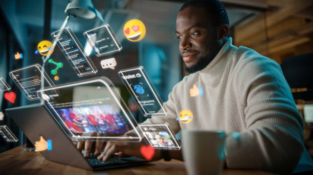 istock African American Project Manager Working on Computer in Office. Augmented Reality Social Media Icons Appear From Worker's Laptop. Internet of Things, Connectivity and Online Concept. 1461626194