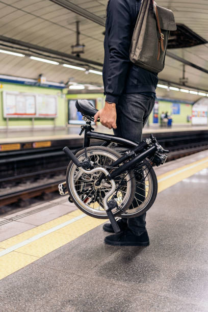 Man Carrying Detachable Bike Stock photo of unrecognized man in the metro holding his detachable bike. detachable stock pictures, royalty-free photos & images