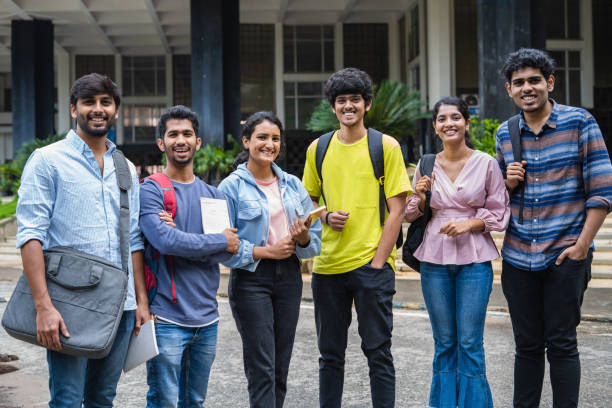 istock Group of happy students standing with books and backpack by looking camera at college campus - concept of friendship, togetherness and education 1461631445