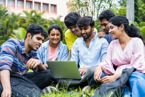 group of young students checking exam results or waiting for project approval on laptop at collage campus - concept of teamwork, bonding and friendship. group of young students checking exam results or waiting for project approval on laptop at collage campus - concept of teamwork, bonding and friendship student result stock pictures, royalty-free photos & images
