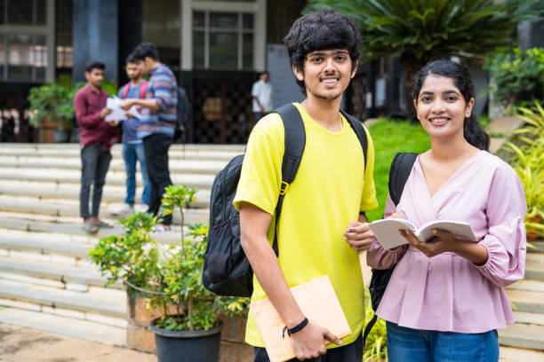 istock happy smiling students looking at camera while preparing for exams by reading books at college campus - concept of knowledge, education and competition. 1461631609