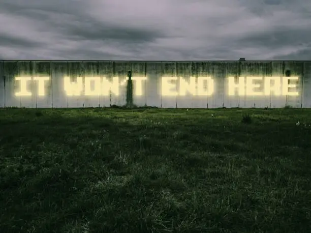 "It won't end here", says a neon sign across a large industrial wall. *** The text was digitally superimposed and a release is provided ***