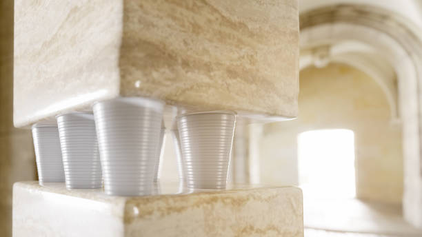 Several white ceramic cups and saucers are arranged on a brown wooden surface. Some cups are tipped over, creating a dynamic and slightly chaotic composition. The lighting is dramatic