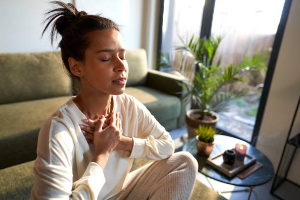 istock Mixed race woman meditating at home with eyes closed 1461634048