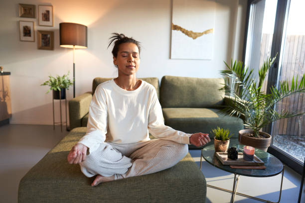 istock Mixed race woman meditating at home with eyes closed 1461634107