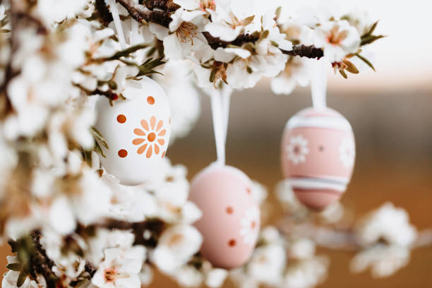 istock Three boho easter eggs in bright beige and brown tones hanging in between almond blossoms on an almond tree on the island Mallorca 1461634885