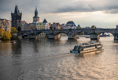 Nice panorama of medieval tower, building, church and Charles bridge, river Vltava with boat. Czech republic, Prague. Nice lighting.