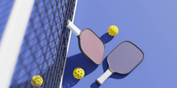 코트의 스포츠 네트에서 피클볼을 하기 위한 라켓과 공. 3d 렌더링 - racket sport 이미지 뉴스 사진 이미지