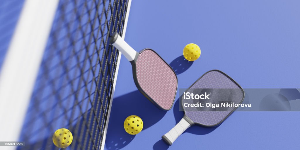 Rackets and balls for playing pickleball at the sports net on the court. 3D rendering Pickleball Stock Photo