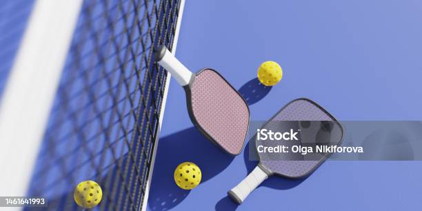 Rackets And Balls For Playing Pickleball At The Sports Net On The Court 3d Rendering Stock Photo - Download Image Now