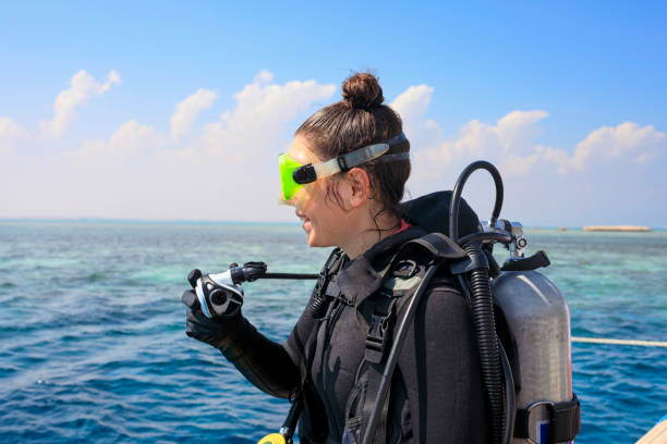 wassersport. hübsche taucherin, attraktive frauen, bereit zum tauchen sportliche frauen. schönes blaues meer im hintergrund. - tauchgerät stock-fotos und bilder