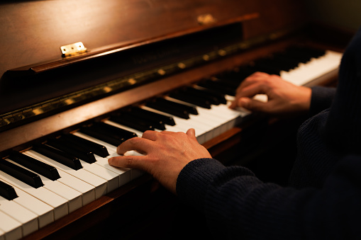 close up of male hands playing piano.