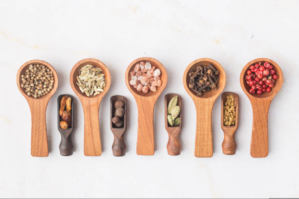 istock Various spices and green herbs in wooden spoons on white table 1461644919