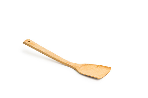 Brown wooden cooking spatula isolated on a white background with copy space