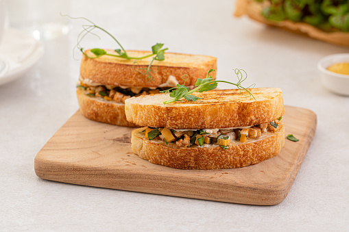 Portion of appetizing tuna sandwich with corn and herbs