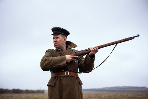a soldier of the first world war holds a front sight weapon to his side. brave cool retro soldier