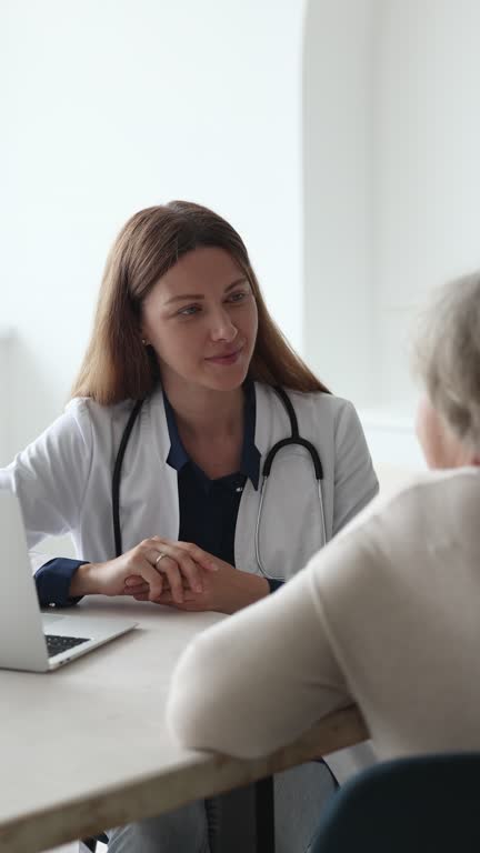 General practitioner talk to elderly patient during visit in clinic