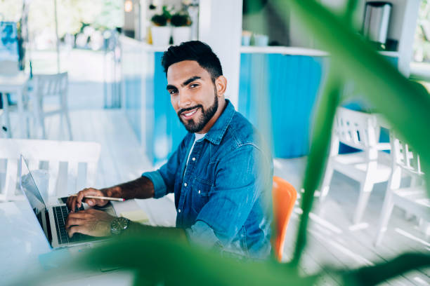 istock Handsome ethnic remote specialist in casual wear enjoying work at outdoors cafe 1461652962