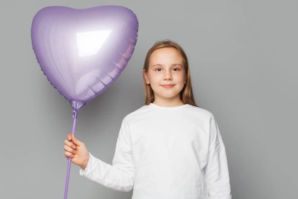 istock Happy cute child with balloon on grey studio background 1461654966