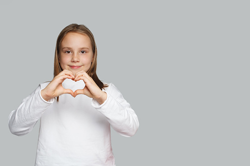 Lovely child girl with shape heart love holiday symbol. Gift heart present.