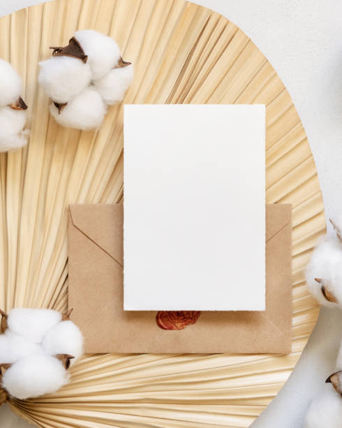 istock Blank card and envelope on dried palm leaf with cotton flowers top view, wedding mockup 1461655757