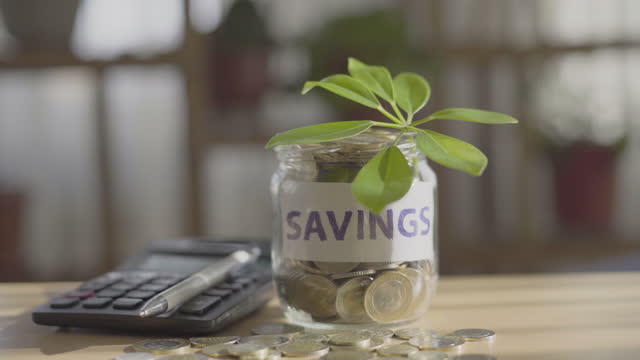 Savings jar and calculator on the table