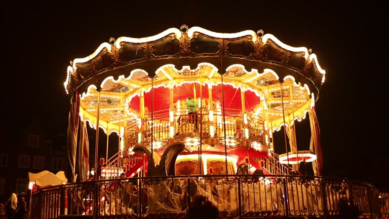 Blurred background of old carousel in the park at night. Three horses and a plane on a traditional fair carousel. Carousel with horses in Gdansk, Poland