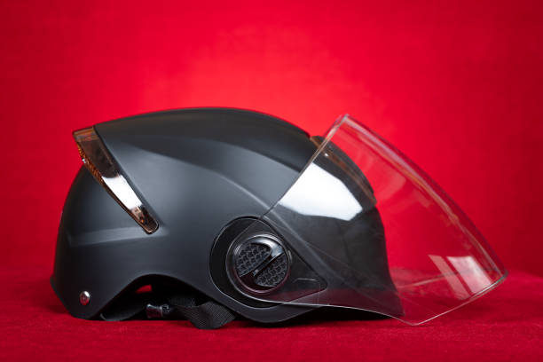 brand new black motobike helmet on a red background
