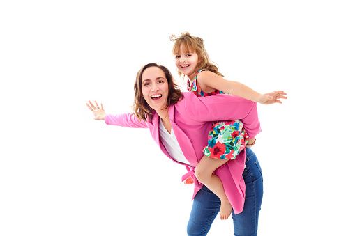 A Happy woman in pink clothes have fun with child girl 6-7 years