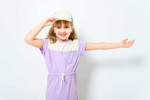 A Little beautiful calm girl with cap isolated on white background