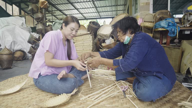 Asian Woman weaving a dry leave for weaving making basket