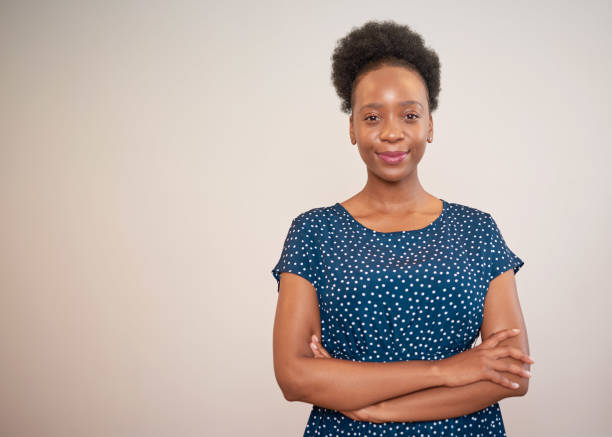 Portrait of Black business woman natural hair smiling beige background stock photo