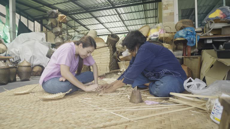 Asian Woman weaving a dry leave for weaving making basket