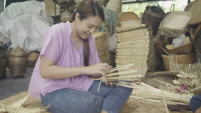 Asian Woman weaving a dry leave for weaving making basket