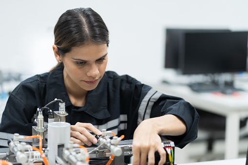 Female engineer training Programmable logic controller with AI robot training kit and mechatronics engineering in the laboratory room