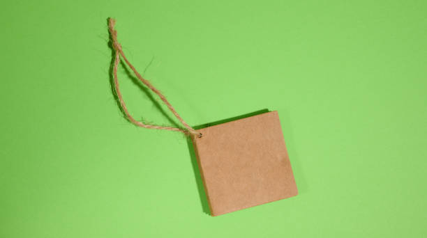 istock Brown paper square paper tag with rope on green background 1461662602