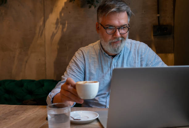 istock Mature businessman working on laptop at cafe 1461664046