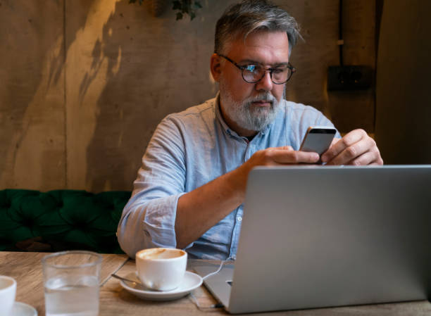 istock Mature businessman working on laptop at cafe 1461664119