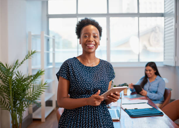 Young Black business woman smiling digital tablet, diverse workplace office