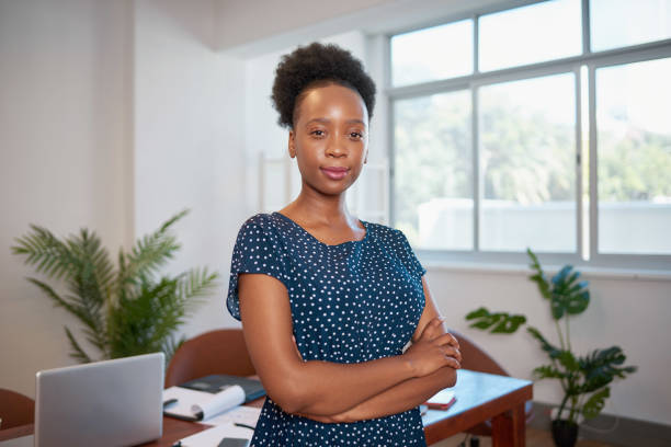 Portrait of serious young Black business woman is bright workplace office plants stock photo