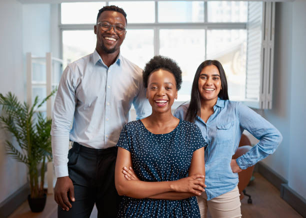 istock Group of smiling business people pose arms folded in office, diverse trio 1461664761